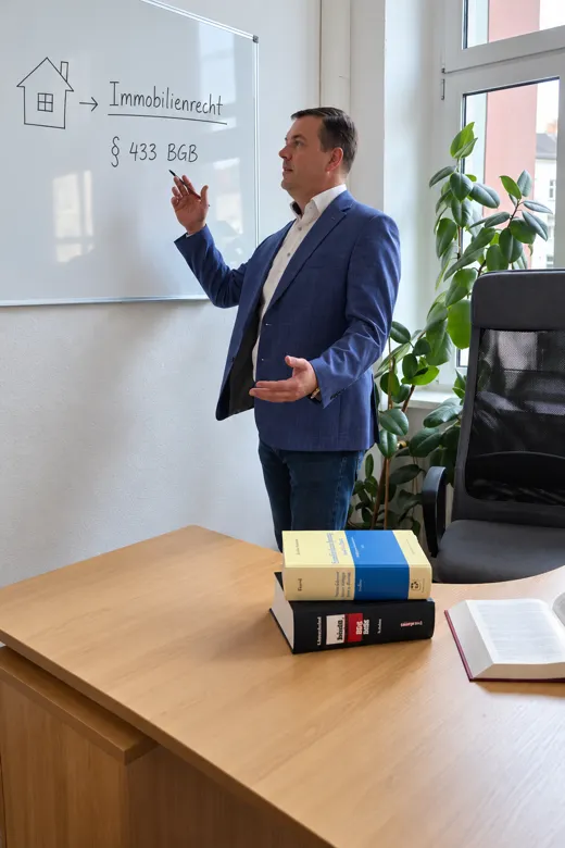 Rechtsanwalt Viktor Tabert erklärt Immobilienrecht am Whiteboard